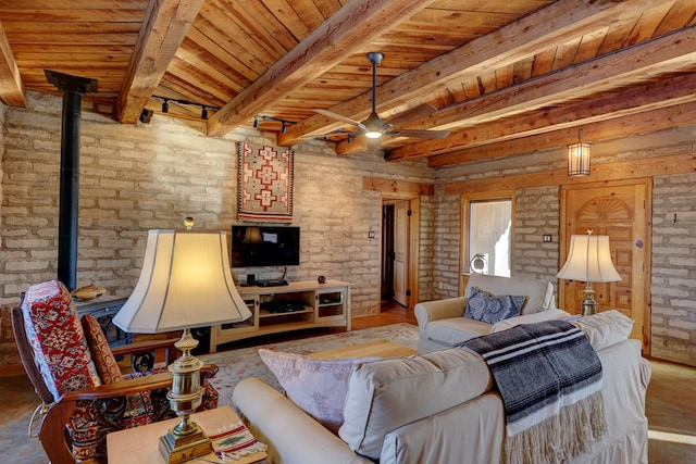 living room with beamed ceiling, a wood stove, brick wall, and wooden ceiling