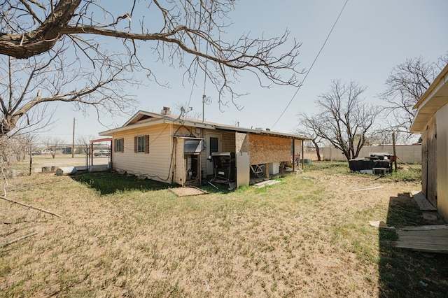 back of property with a yard, a chimney, and fence