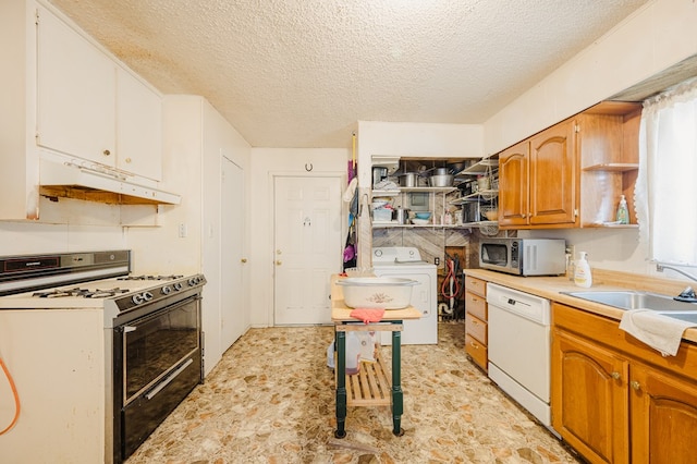 kitchen with under cabinet range hood, light countertops, washer / dryer, white appliances, and a textured ceiling