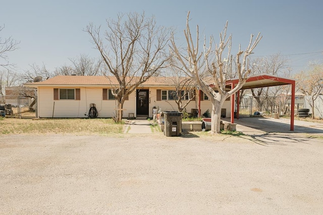 view of front of house featuring a carport, driveway, and fence