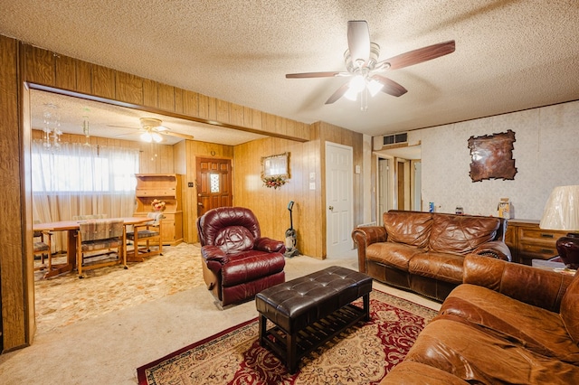 living area featuring carpet flooring, a textured ceiling, visible vents, and a ceiling fan