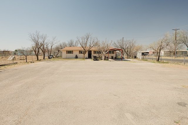 view of front of house with fence and dirt driveway