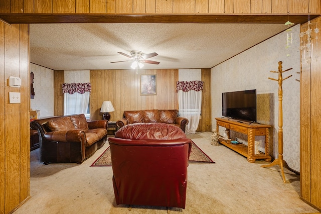 carpeted living room with a textured ceiling, ceiling fan, and wood walls