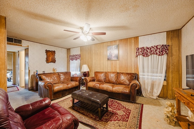 living room with visible vents, a textured ceiling, ceiling fan, and carpet flooring