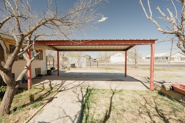 view of patio / terrace with a carport, fence, and driveway