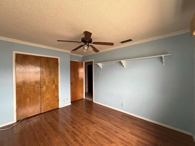 unfurnished bedroom featuring wood finished floors, visible vents, a closet, a textured ceiling, and crown molding