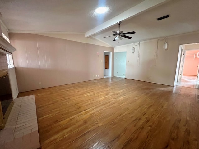 unfurnished living room with visible vents, lofted ceiling with beams, a ceiling fan, and wood finished floors