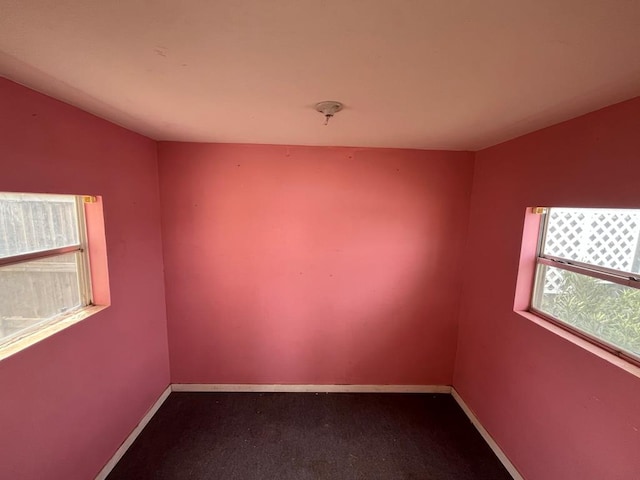 carpeted spare room featuring baseboards