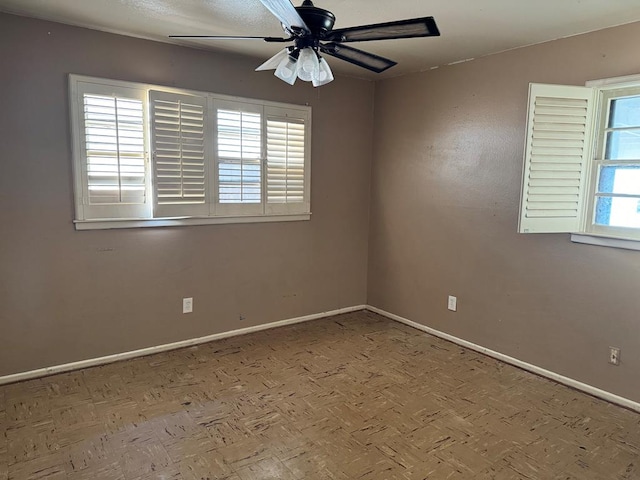 unfurnished room featuring ceiling fan and a healthy amount of sunlight