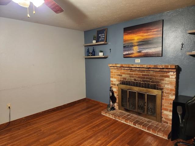 living room featuring ceiling fan, a fireplace, a textured ceiling, and hardwood / wood-style flooring