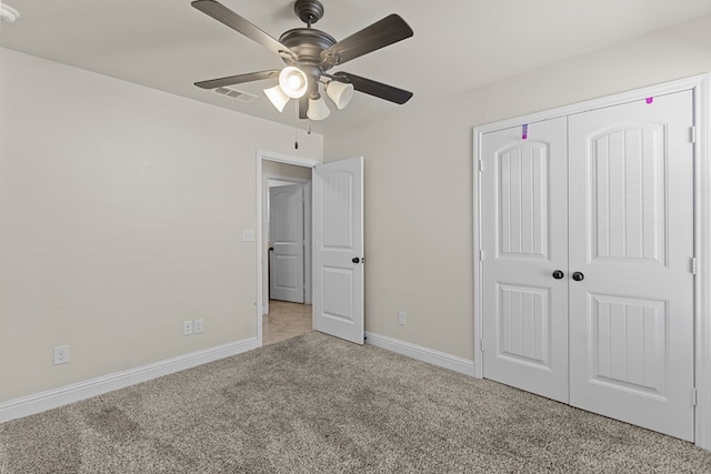 unfurnished bedroom featuring ceiling fan, light colored carpet, and a closet