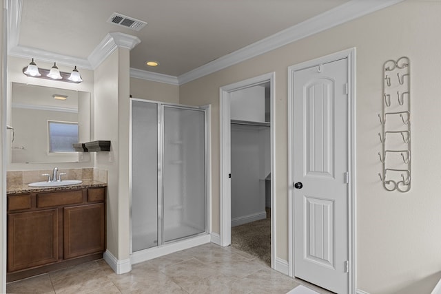 bathroom with vanity, tile patterned floors, a shower with door, and ornamental molding