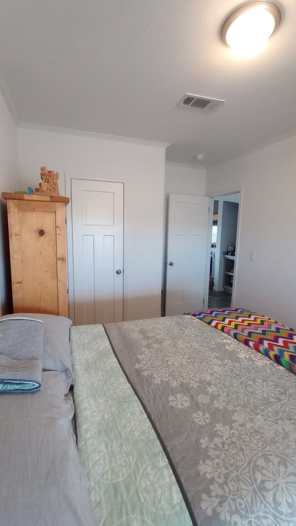 bedroom featuring connected bathroom and crown molding