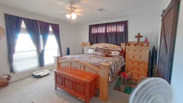 bedroom with ceiling fan, light colored carpet, and multiple windows