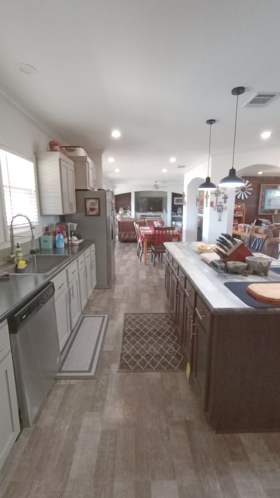 kitchen with sink, ceiling fan, decorative light fixtures, dark hardwood / wood-style flooring, and stainless steel appliances