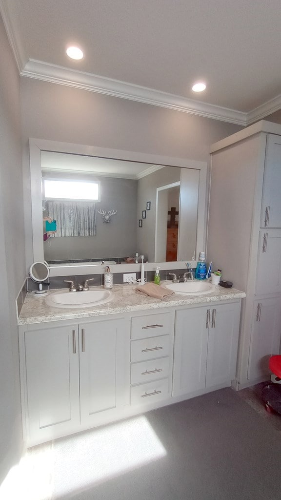 bathroom with crown molding and vanity