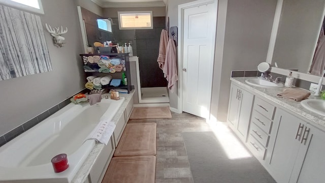 bathroom with crown molding, hardwood / wood-style floors, vanity, and independent shower and bath