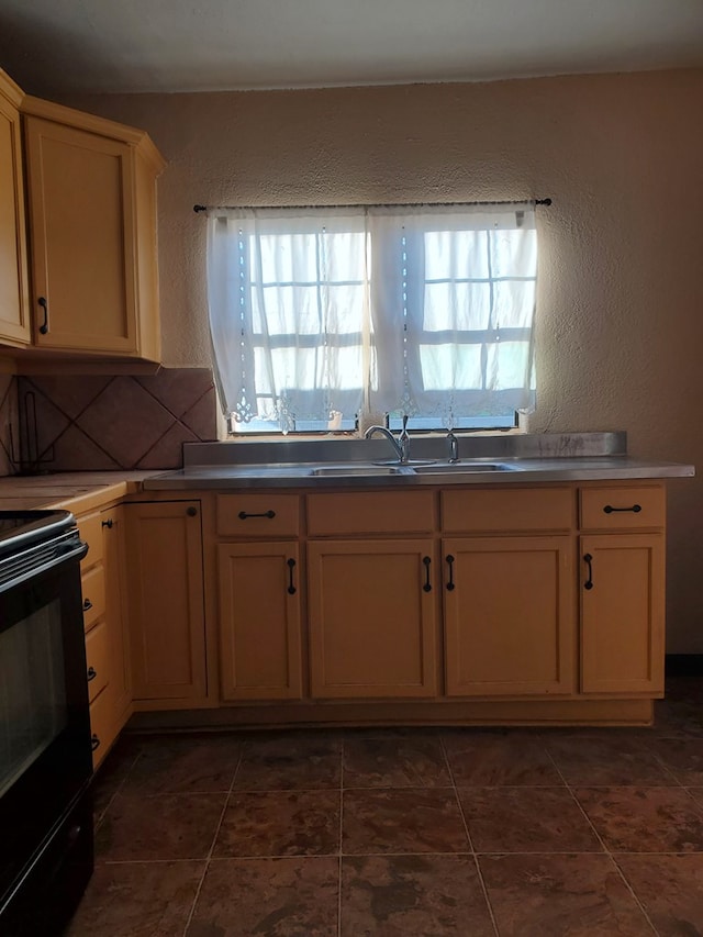 kitchen with a healthy amount of sunlight, black range with electric stovetop, decorative backsplash, and dark tile patterned floors