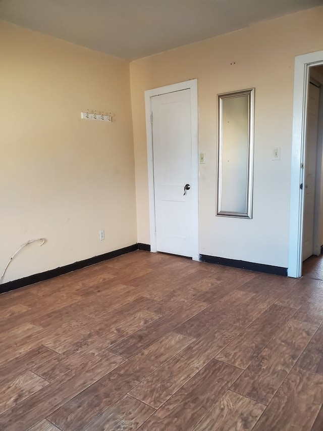 unfurnished room featuring dark wood-type flooring