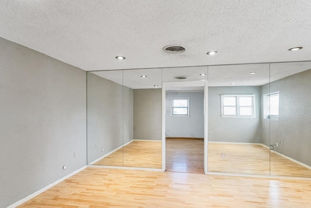 unfurnished bedroom with wood-type flooring and a textured ceiling