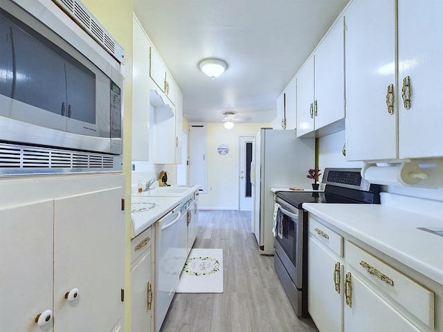 kitchen with light hardwood / wood-style flooring, sink, white cabinetry, and stainless steel appliances