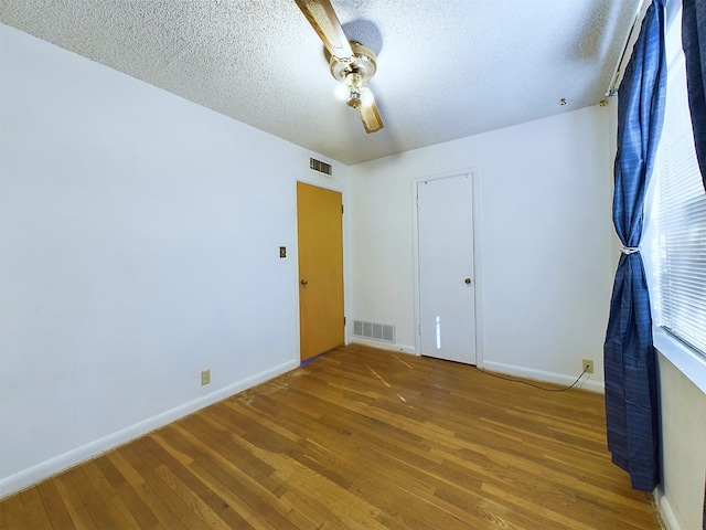 unfurnished room featuring a textured ceiling and hardwood / wood-style floors