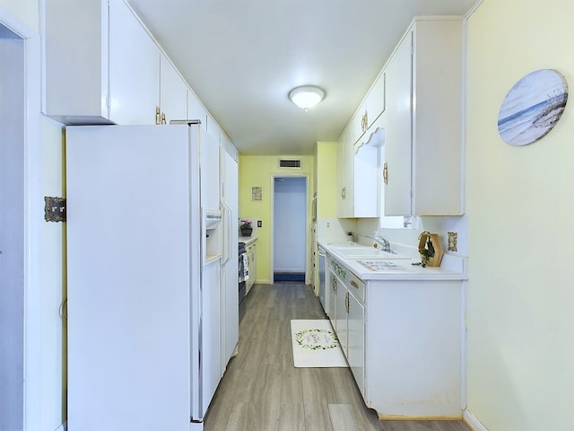 kitchen with dishwasher, sink, white cabinetry, light wood-type flooring, and white fridge with ice dispenser