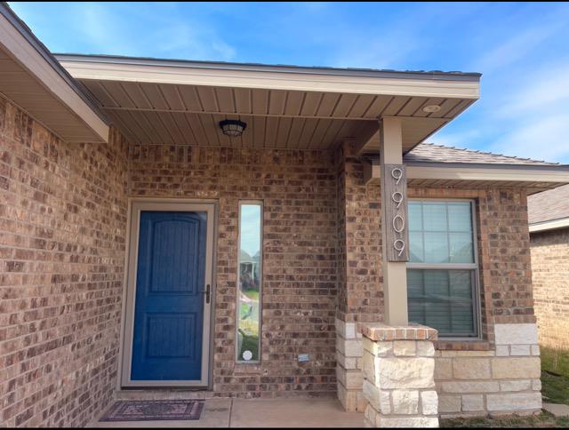 entrance to property featuring brick siding