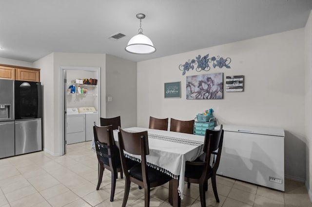 dining area featuring visible vents, washer and clothes dryer, and light tile patterned floors