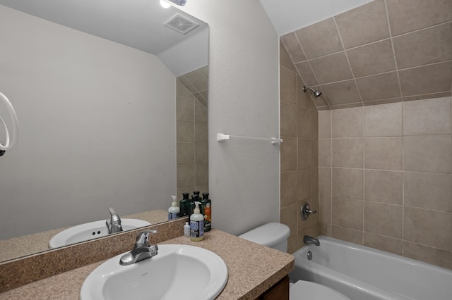 bathroom with visible vents, toilet, lofted ceiling, vanity, and shower / washtub combination