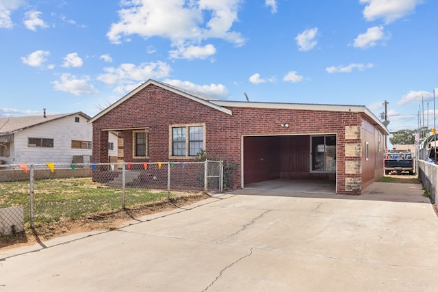 view of front of home with an attached garage, a fenced front yard, concrete driveway, and brick siding