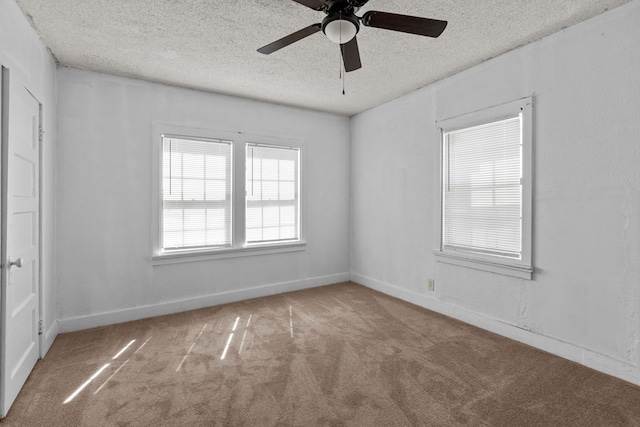 carpeted spare room with a ceiling fan, a textured ceiling, and baseboards