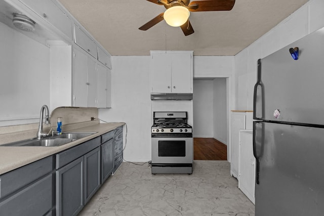 kitchen with appliances with stainless steel finishes, light countertops, white cabinetry, and a sink