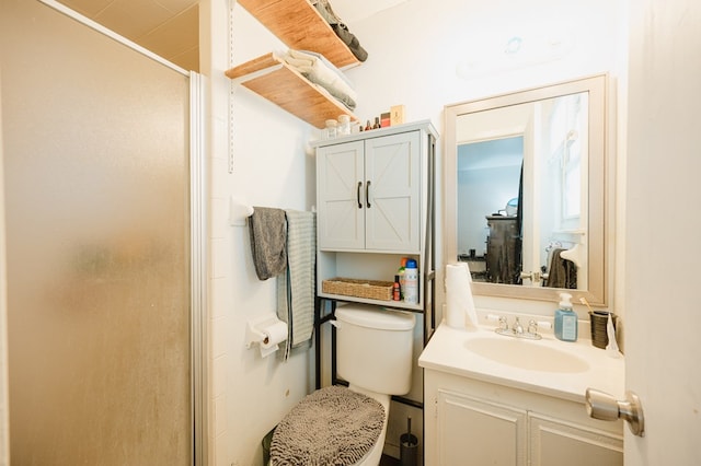 bathroom with vanity, toilet, and a shower with shower door