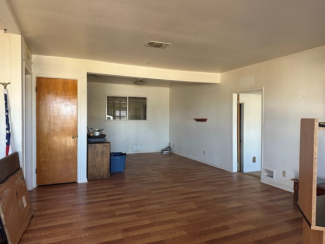 empty room featuring dark wood-type flooring and a textured ceiling