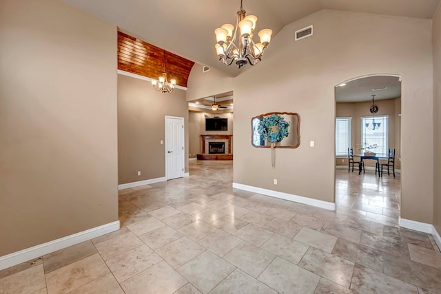 tiled spare room with ceiling fan with notable chandelier and high vaulted ceiling