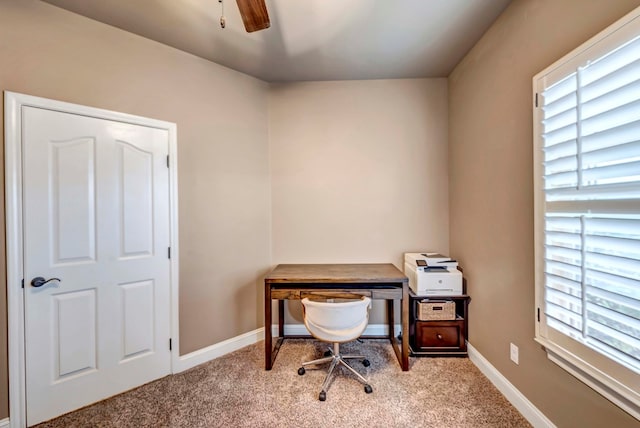 carpeted home office with ceiling fan and a healthy amount of sunlight