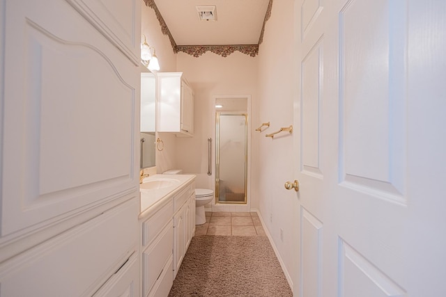 bathroom with vanity, toilet, tile patterned flooring, and a shower with door