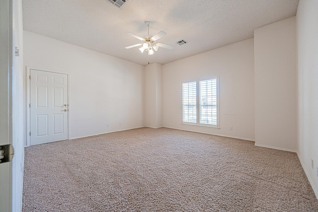 carpeted empty room with ceiling fan and a textured ceiling