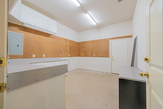 interior space featuring electric panel and a textured ceiling