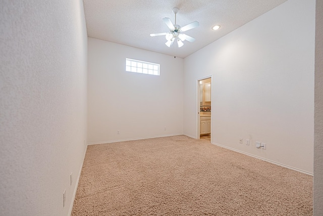 unfurnished room featuring light carpet, ceiling fan, and a textured ceiling