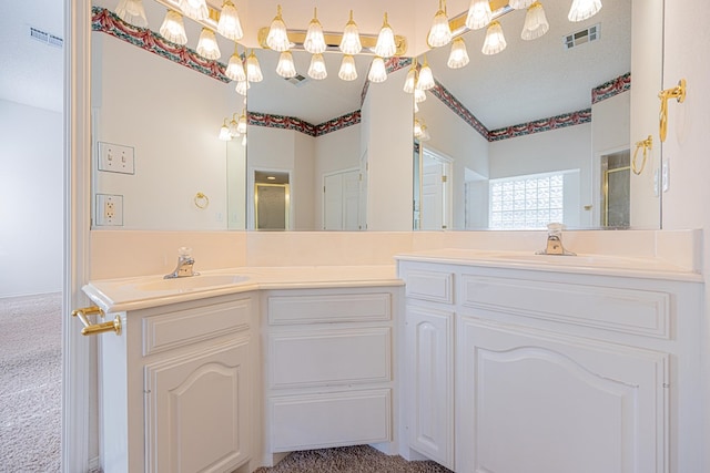 bathroom with vanity, a shower with door, and a textured ceiling