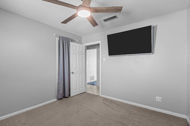 unfurnished bedroom featuring visible vents, a textured ceiling, baseboards, and carpet floors