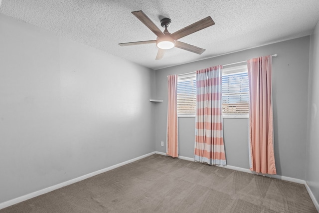 spare room featuring a textured ceiling, baseboards, carpet, and a ceiling fan