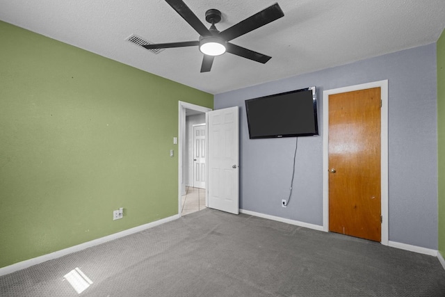 unfurnished bedroom featuring visible vents, baseboards, carpet flooring, a textured ceiling, and a ceiling fan