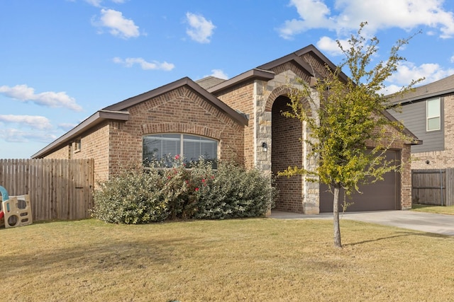 view of front of property with concrete driveway, brick siding, fence, and a front lawn