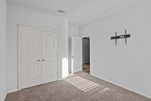 unfurnished bedroom featuring a closet, carpet, visible vents, and baseboards