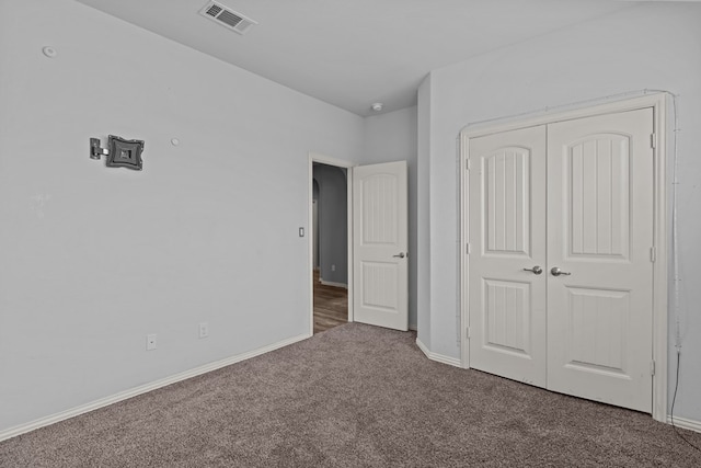 unfurnished bedroom featuring carpet, a closet, visible vents, and baseboards