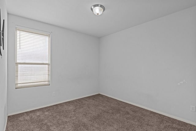 unfurnished room with carpet floors and baseboards