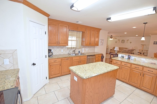 kitchen with pendant lighting, sink, stainless steel appliances, light stone counters, and a kitchen island